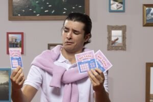 Una persona sostiene varios boletos de lotería en abanico