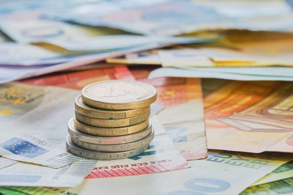 Monedas de euro apiladas sobre billetes